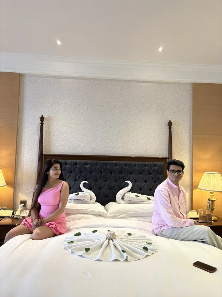 Sitting on the bed beside towel swans folded into a heart