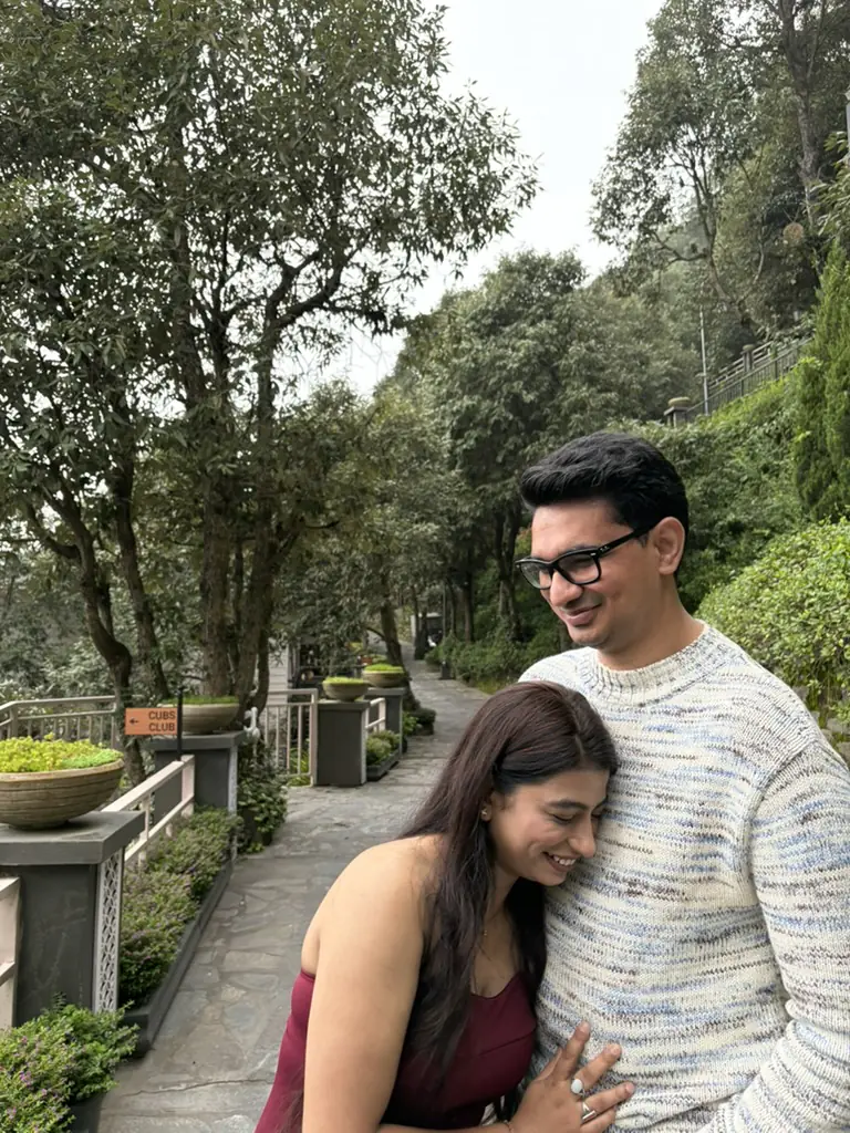 Divya laughing against my chest on a tree-lined path